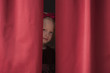 Caucasian girl peering from backstage
