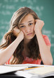 Bored Caucasian teenager studying on classroom