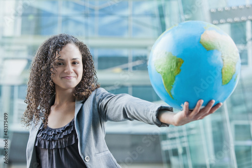 Photo: Caucasian businesswoman holding globe Caucasian businesswoman holding globe