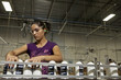 Hispanic worker holding cans on assembly line