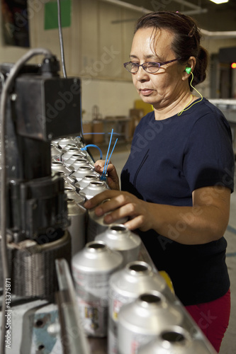 Photo: Hispanic woman working on assembly line Hispanic woman working on assembly line