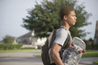 Mixed race teenager carrying skateboard