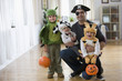 Mixed race father and sons in Halloween costumes