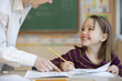 Foto: Teacher helping Caucasian girl studying in classroom Teacher helping Caucasian girl studying in classroom