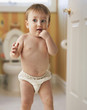 Mixed race baby boy standing in bathroom