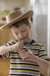 Caucasian boy in cowboy hat eating pudding