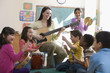 Teacher playing guitar for students in classroom