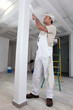 Tradesman painting a column