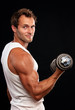Photo: Muscular man lifting dumbbell on black background Muscular man lifting dumbbell on black background