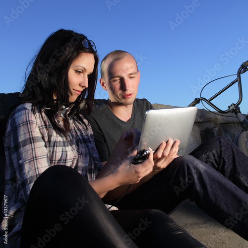 Photo: beauty girl and boy with tablet pc outdoors beauty girl and boy with tablet pc outdoors
