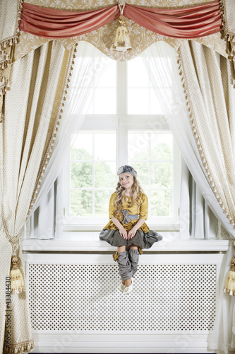 Photo: Girl sitting on the windowsill Girl sitting on the windowsill