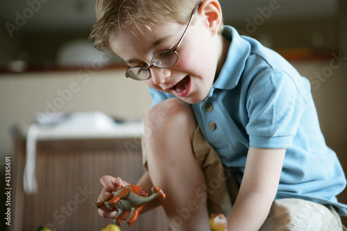 Photo: Little boy playing with toy dinosaur Little boy playing with toy dinosaur