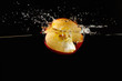 Halved apple falling into the water with a splash