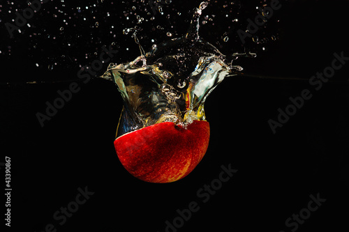 Photo: Halved fresh apple falling into the water with a splash Halved fresh apple falling into the water with a splash