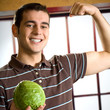 Cheerful man with cabbage, showing biceps
