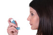 Woman using her inhaler
