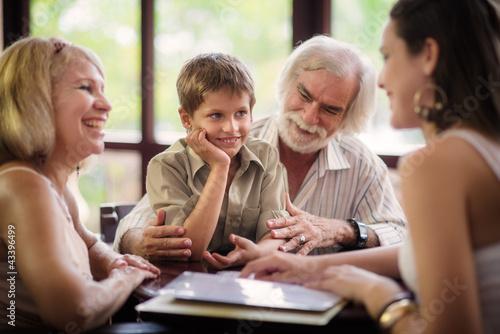 Photo: Happy parents and grandparents with boy in bar Happy parents and grandparents with boy in bar