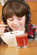 Photo: Boy Listening To MP3 Player Whilst Eating Breakfast Boy Listening To MP3 Player Whilst Eating Breakfast