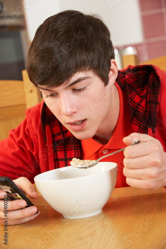 Photo: Teenage Boy Teenage Texting Whilst Eating Breakfast Teenage Boy Teenage Texting Whilst Eating Breakfast