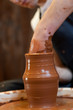 hands of a potter, creating an earthen jar on the circle