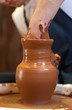 hands of a potter, creating an earthen jar on the circle