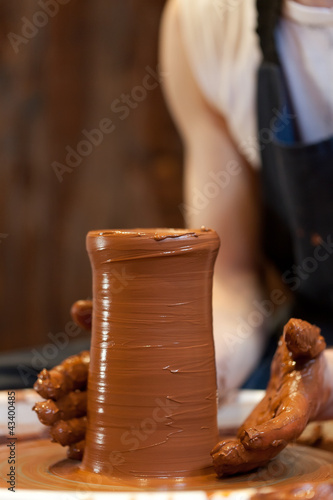 Photo: hands of a potter, creating an earthen jar on the circle hands of a potter, creating an earthen jar on the circle