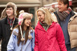 Teenage Family Walking Along Snowy Town Street In Ski Resort