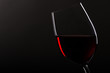 Weinglas mit Rotwein vor schwarzem Hintergrund