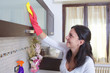 Photo: beautiful young housewife cleaning the furniture in the kitchen beautiful young housewife cleaning the furniture in the kitchen