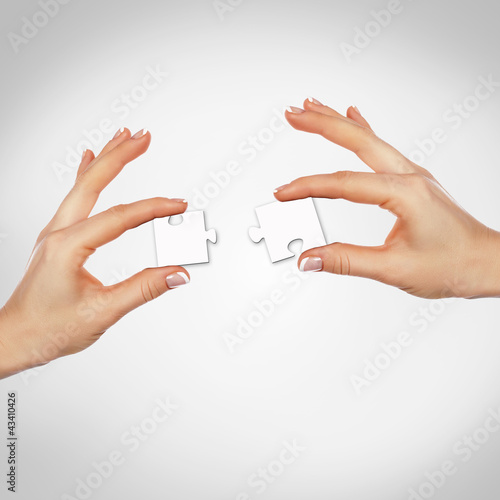 Photo: Puzzle pieces and human hand Puzzle pieces and human hand