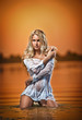 sexy blonde woman in water at sunset .Beautiful swimsuit model