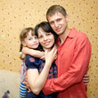 Father, mother and daughter hugging and smiling