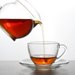 Tea is poured into a transparent cup