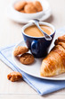 Cup of espresso with biscotti and croissant