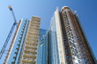 Modern high-rise building under construction and a crane.