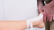 Physiotherapist strapping the foot of a woman