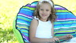 Girl with a tablet sitting in a chair. Thumbs up. Ok.