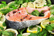 Red fish with lemon, parsley and pepper on plate close up.