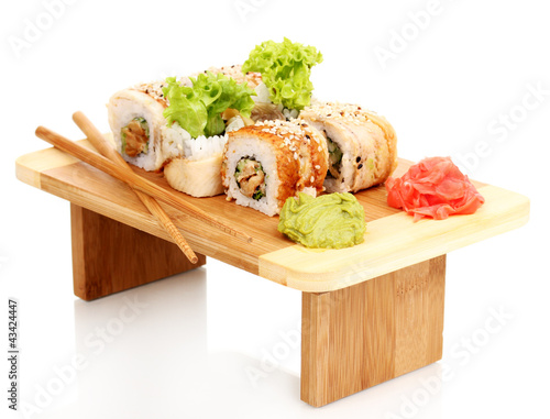 Photo: Tasty rolls served on wooden plate isolated on white Tasty rolls served on wooden plate isolated on white