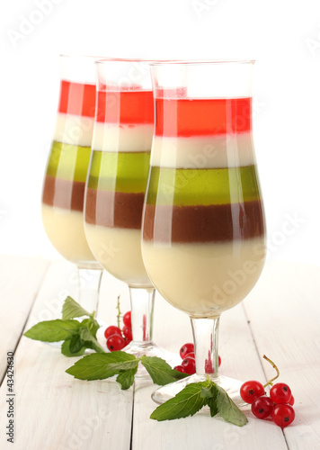Photo: fruit jelly in glasses, redcurrants and mint on wooden table fruit jelly in glasses, redcurrants and mint on wooden table