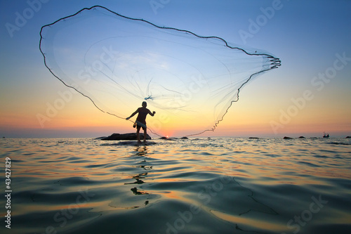 Photo: throwing fishing net during sunrise throwing fishing net during sunrise