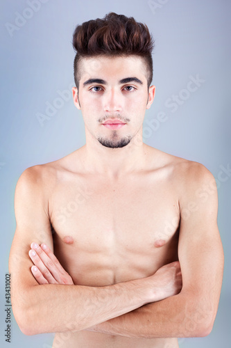 Photo: Handsome young man portrait on grey background Handsome young man portrait on grey background