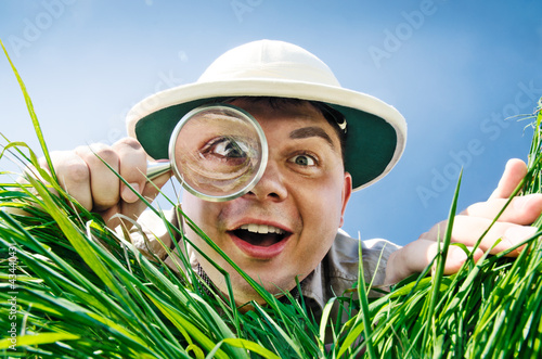 Photo: Young Man Looking through a Magnifying Glass Young Man Looking through a Magnifying Glass