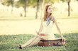Redhead girl sitting at bag at outdoor.