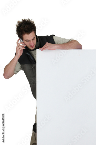 Photo: Tradesman standing behind a blank sign Tradesman standing behind a blank sign