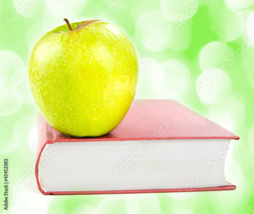 Photo: A green apple on a book A green apple on a book