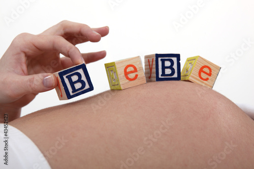 Photo: pregnant woman with baby letters on belly pregnant woman with baby letters on belly