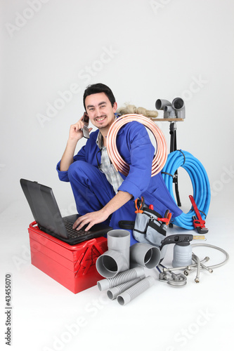Photo: Labourer surrounded by tools and equipment Labourer surrounded by tools and equipment