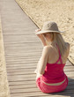 girl sitting back on track by the sea
