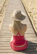 girl sitting back on track by the sea